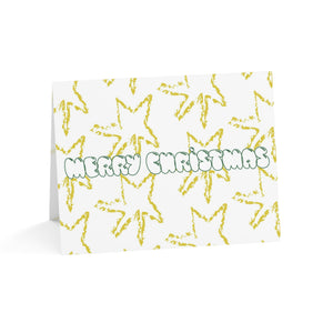 christmas cards with yellow crayon like drawing ofstars and green bubble letters that say merry christmas